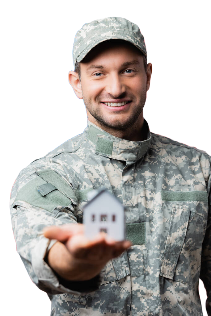 Picture of a smiling veteran with tiny house in the palm of his hand.